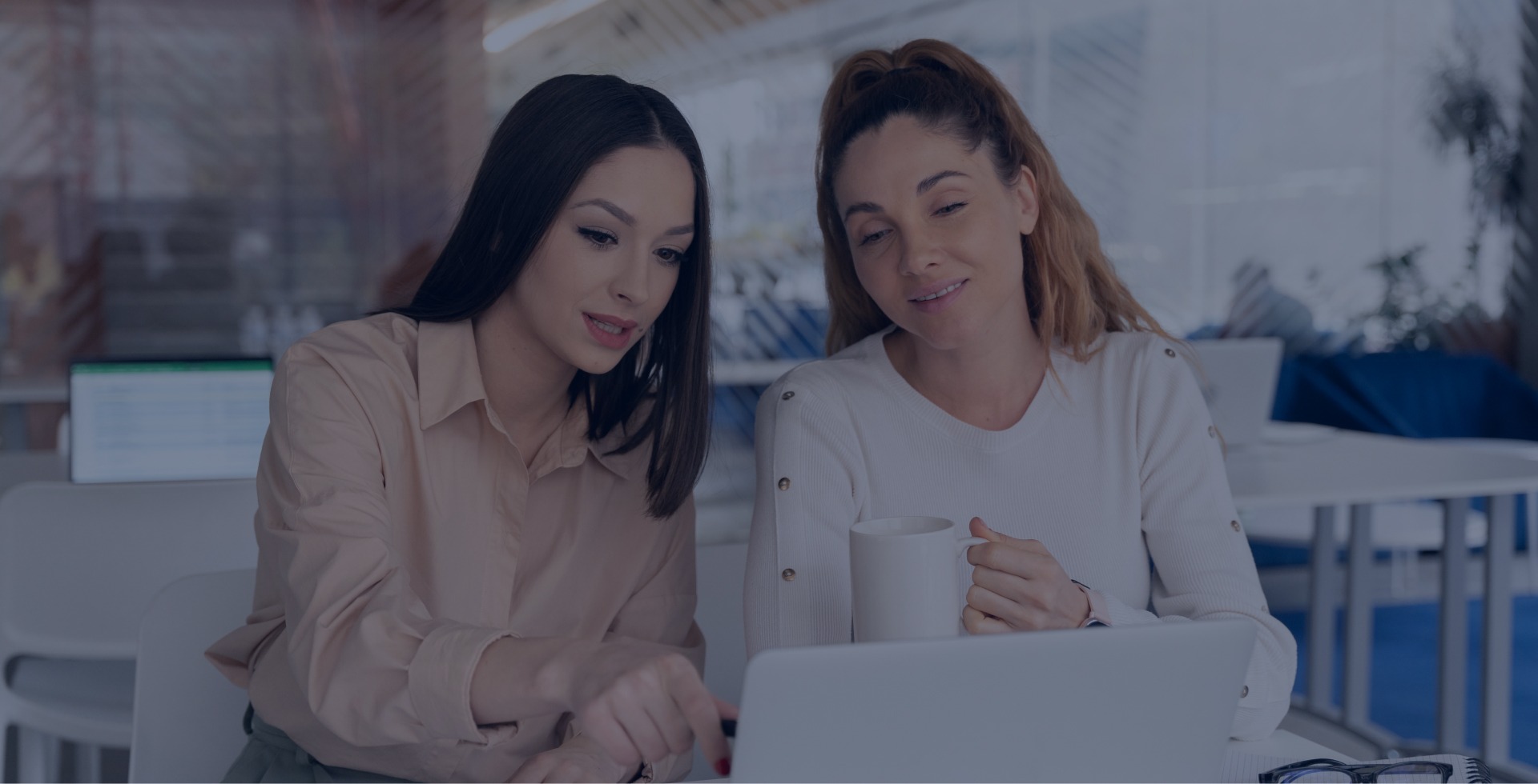 Duas pessoas olhando para o computador e conversando